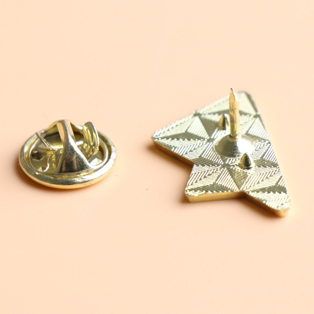 Popierinio lektuvelio emalio seges nugarine puse su metaliniu drugelio formos uzsegimu